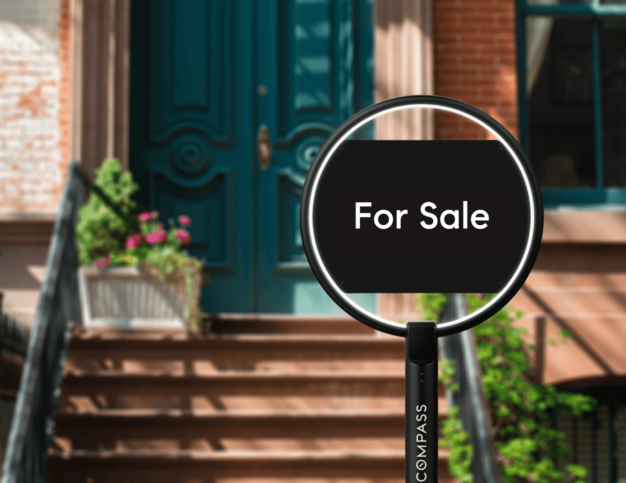 Home entrance with a magnifying glass displaying a For Sale sign.