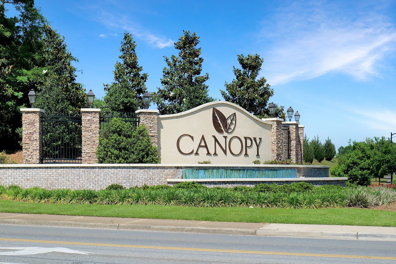 A ground-level view of the entrance sign for "Canopy," indicating the name of the residential community.