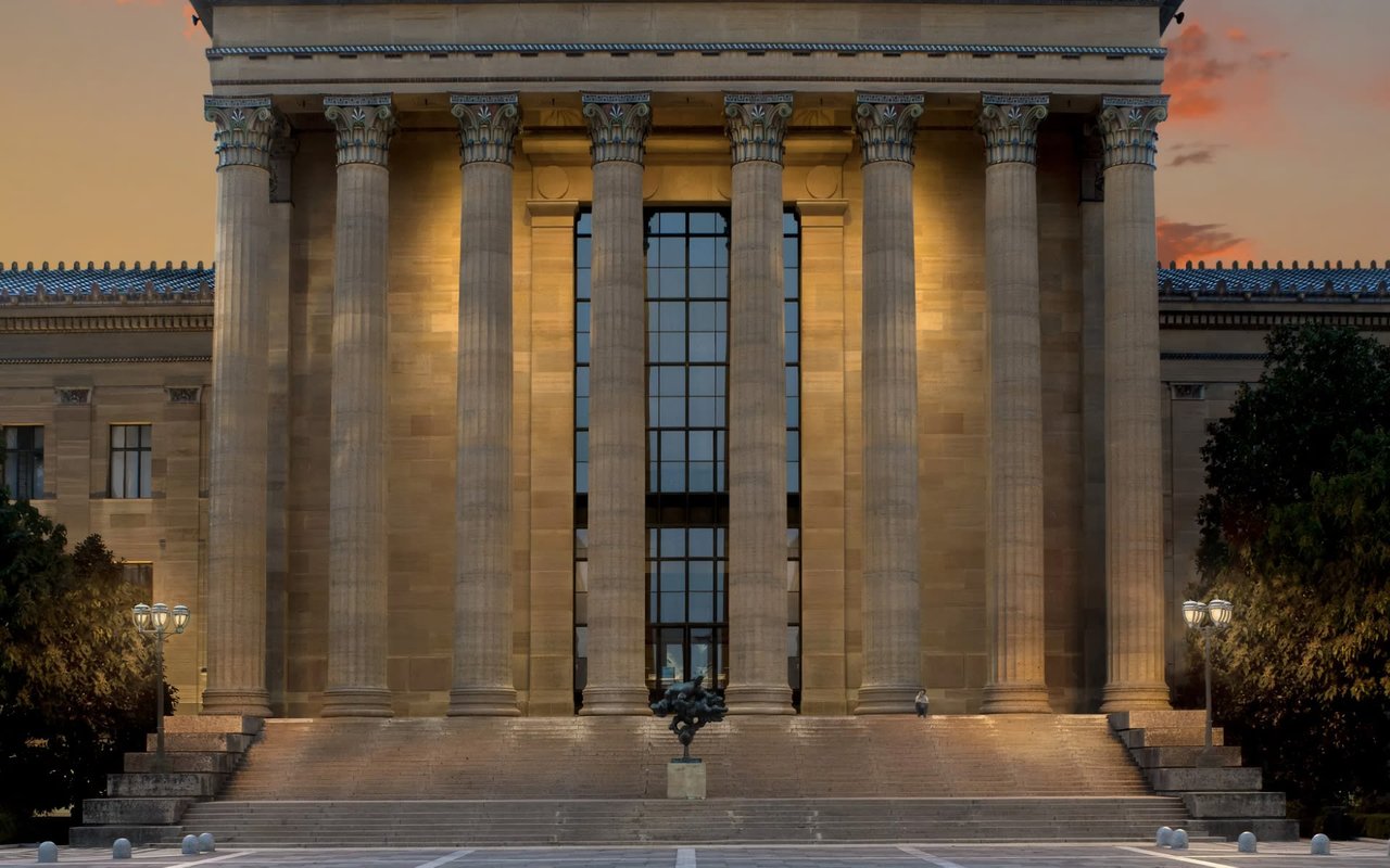  A majestic, illuminated facade of the Philadelphia Museum of Art at dusk.