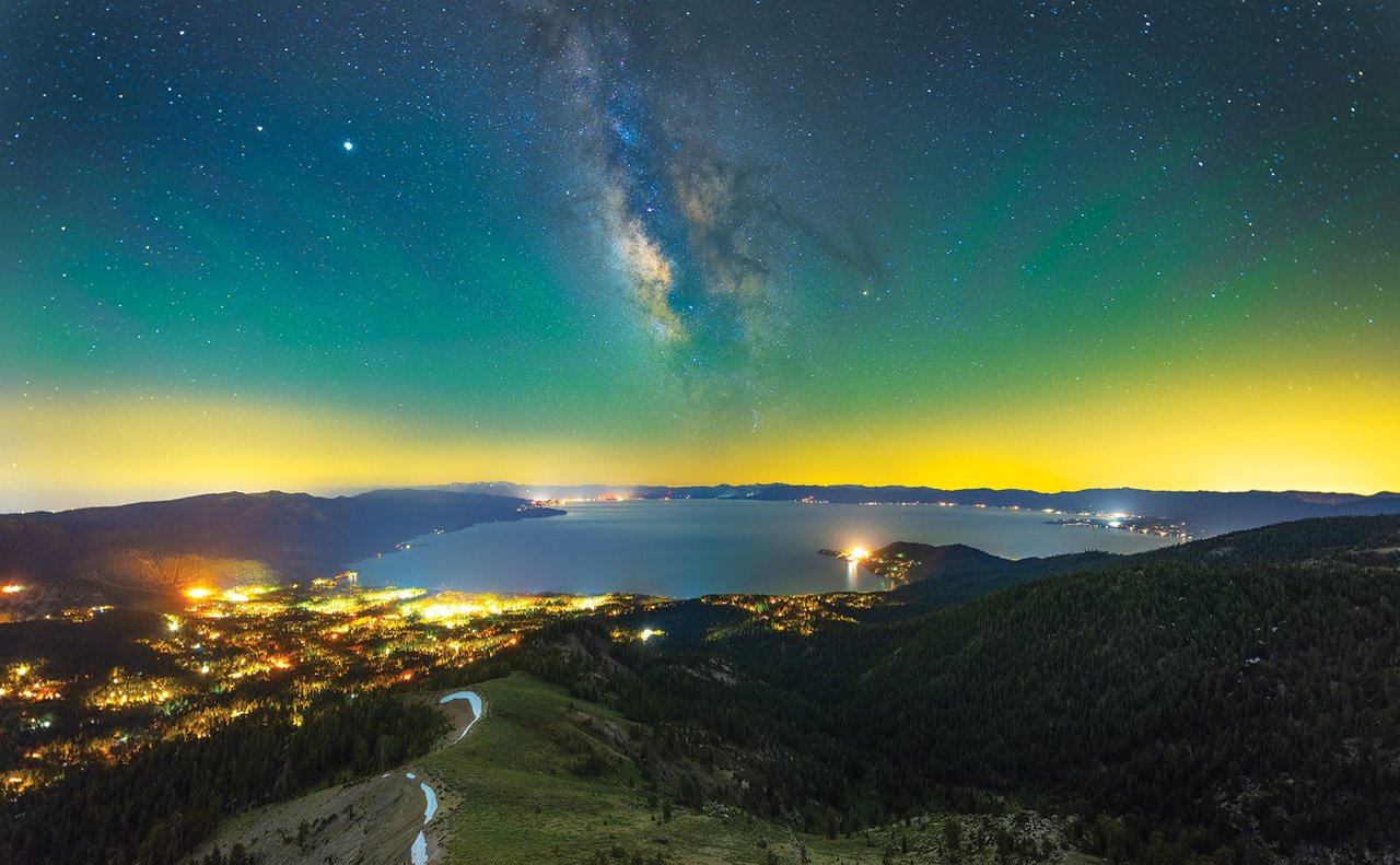 Tahoe’s South Shore (foreground) and North Shore (in the distance) glow under the Milky Way on a summer night, photo by Justin Majeczky