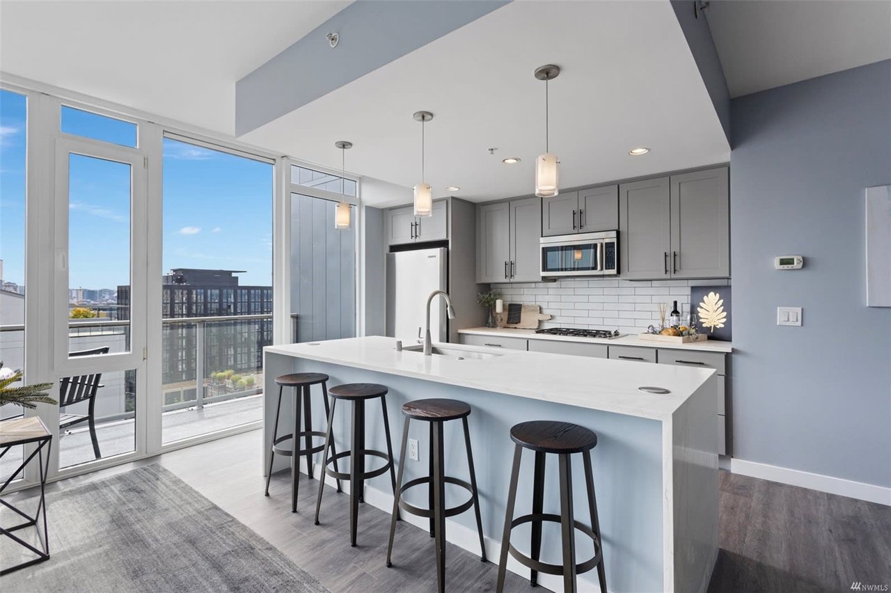 Sleek and modern luxury condo kitchen with panoramic city views.