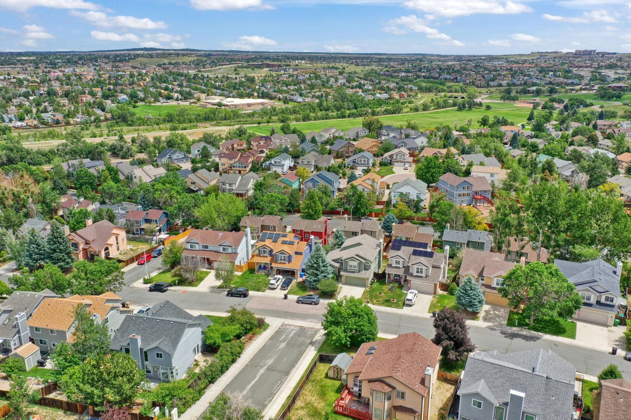 An aerial view of a suburban neighborhood with houses, trees, and roads