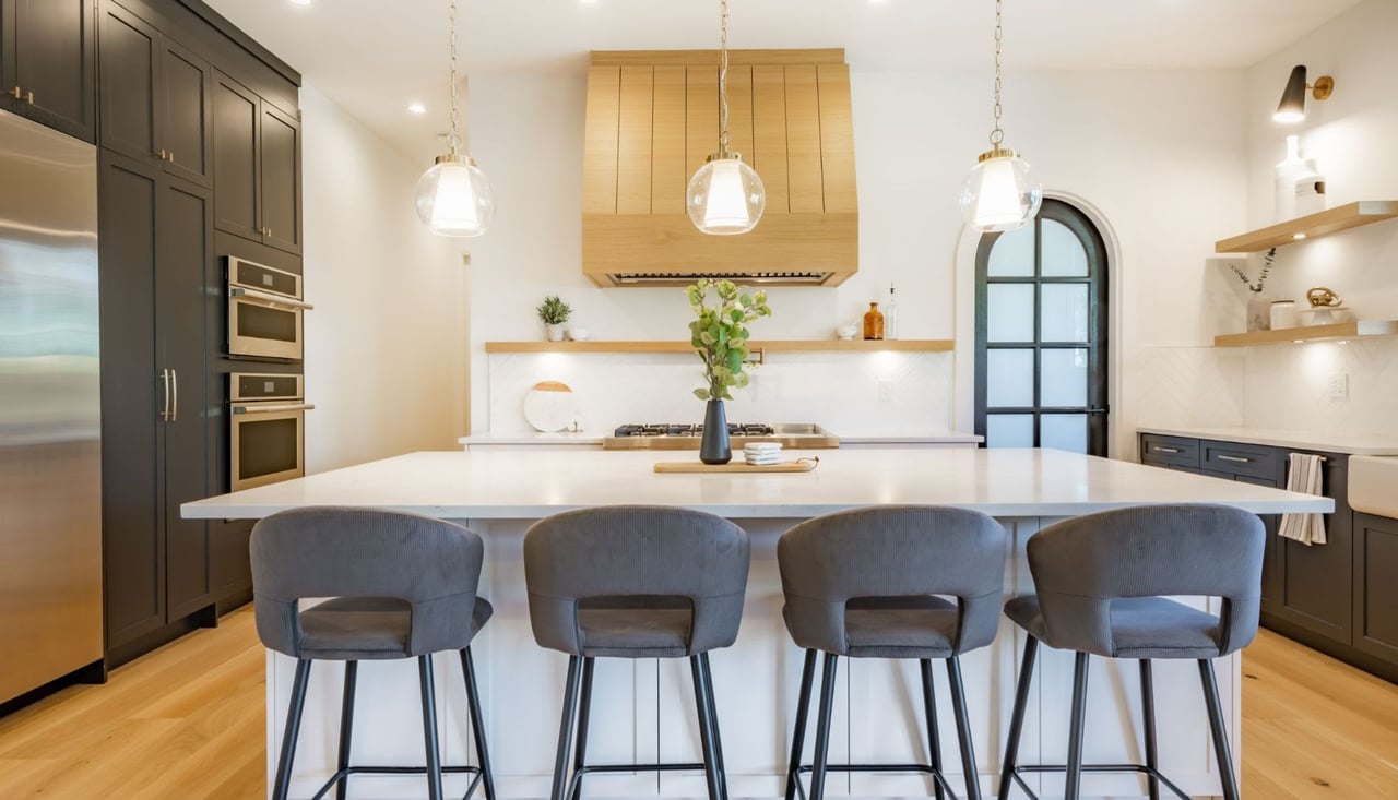  A contemporary kitchen is shown from an eye-level perspective, focusing on a large white kitchen island.
