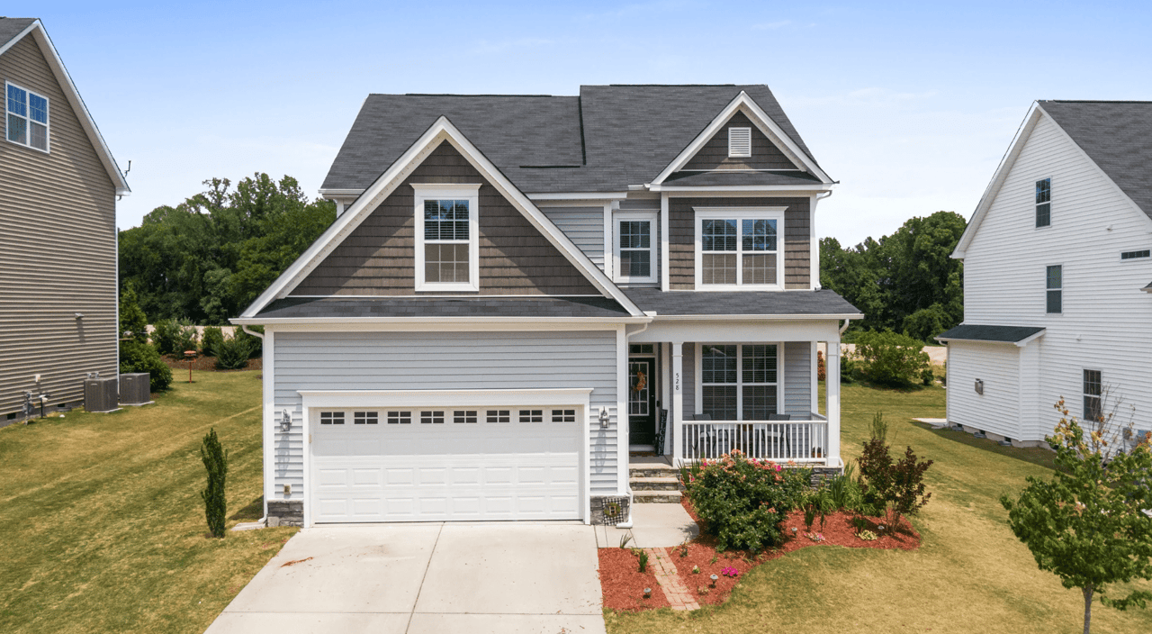 A gray and white house with a white garage door.