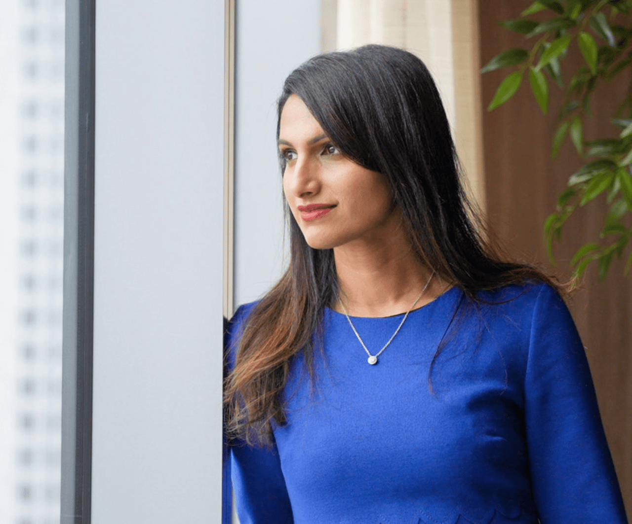 Shalini Sadda in side view looking out the window, featured on her real estate website to reflect calm and thoughtful presence