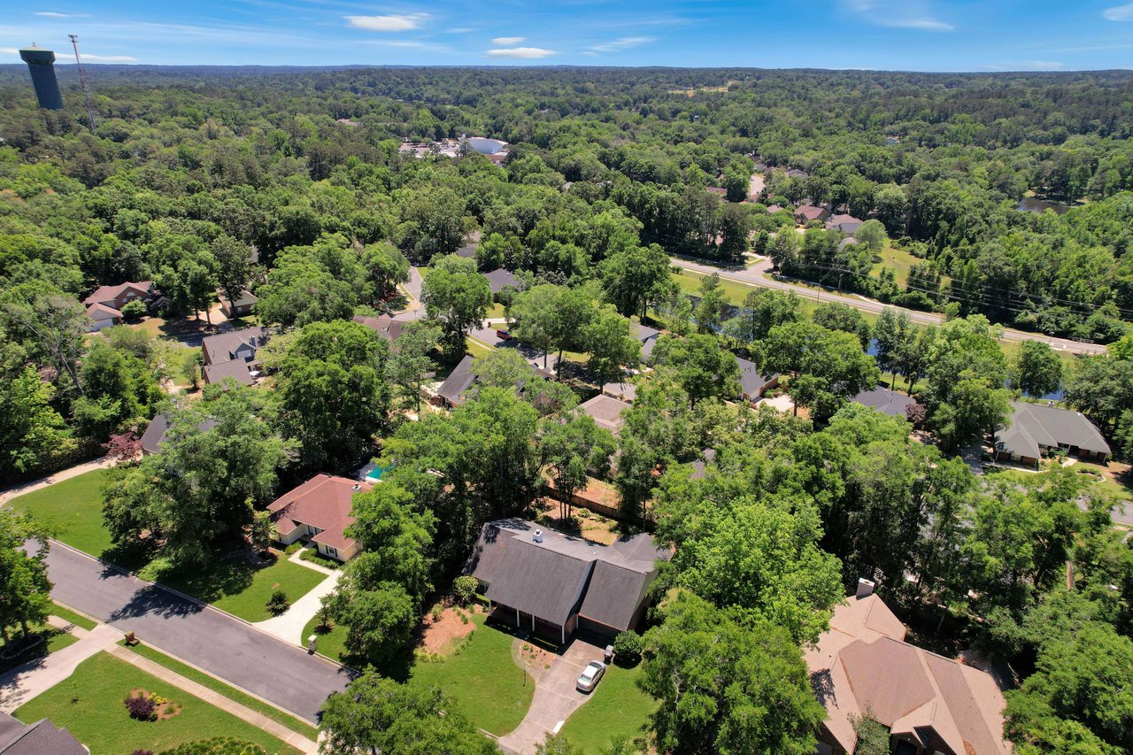 An aerial view of a residential area in Tredington Park with winding roads and houses surrounded by dense greenery.