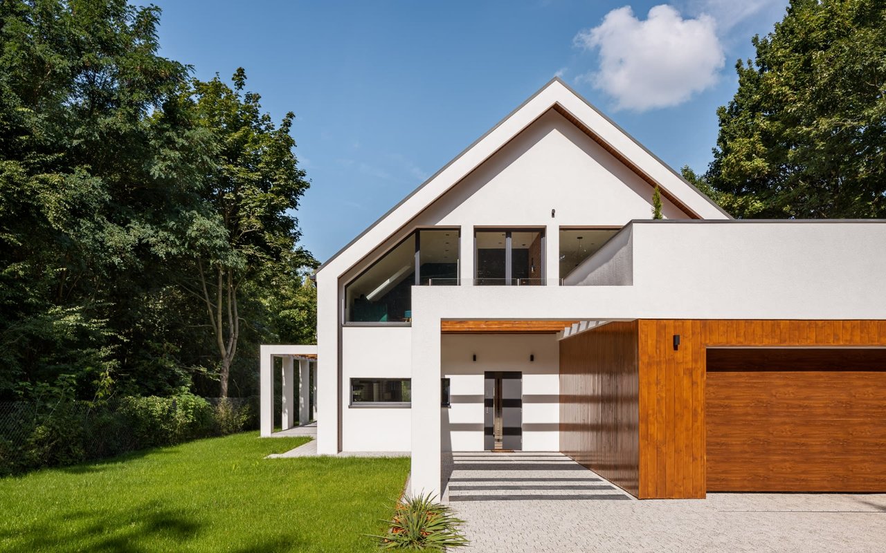 A white house with a brown wooden garage door.