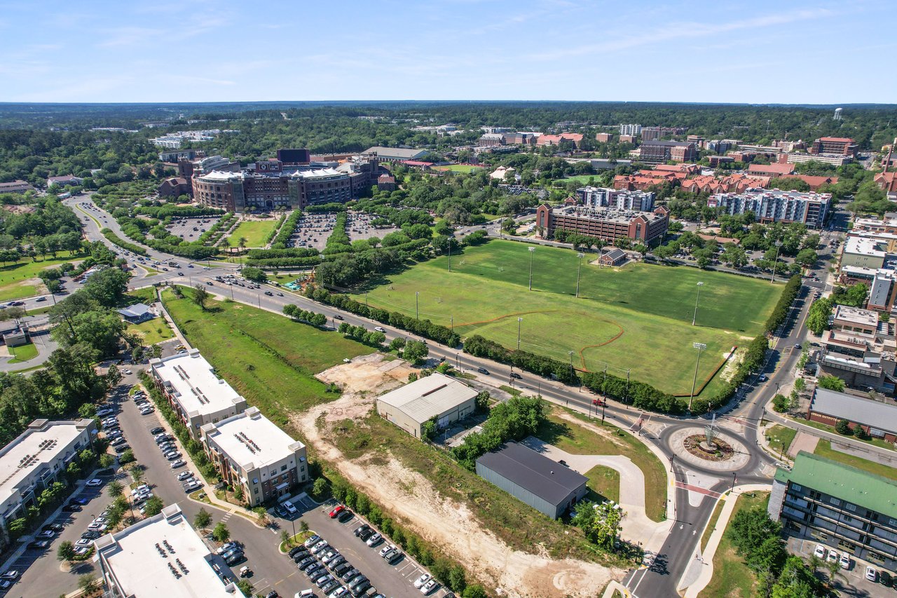 An aerial view of a section of College Town, showing residential buildings, streets, and green spaces within an urban environment.
