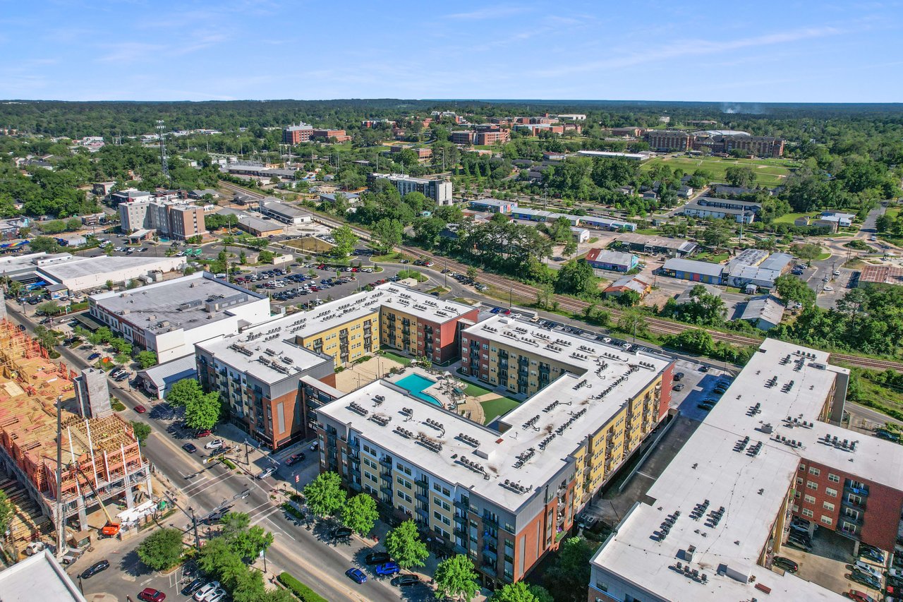 A broader aerial view of College Town, providing a wide perspective of the residential and commercial buildings, streets, and overall layout.