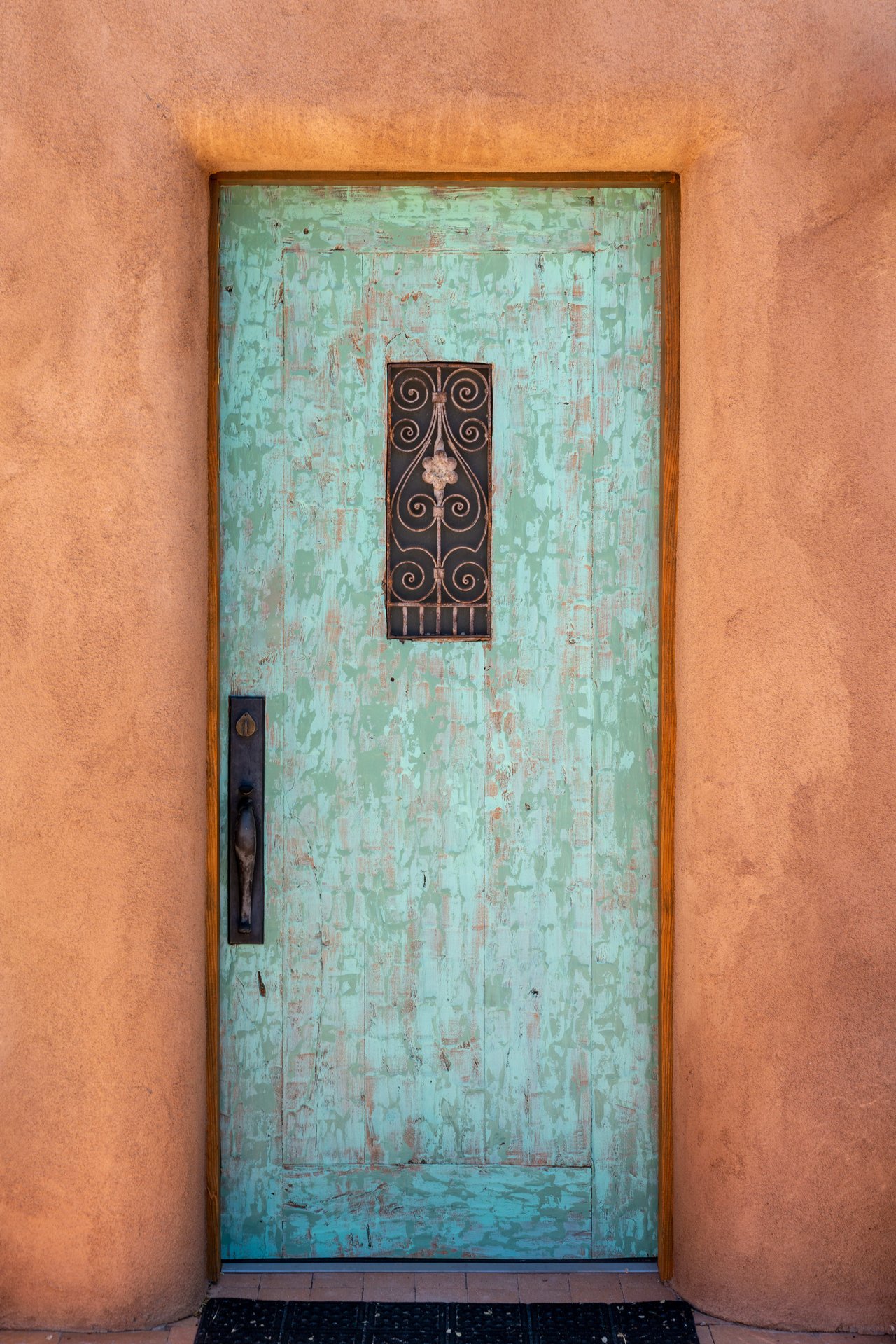 an old light blue door with metal design in the center