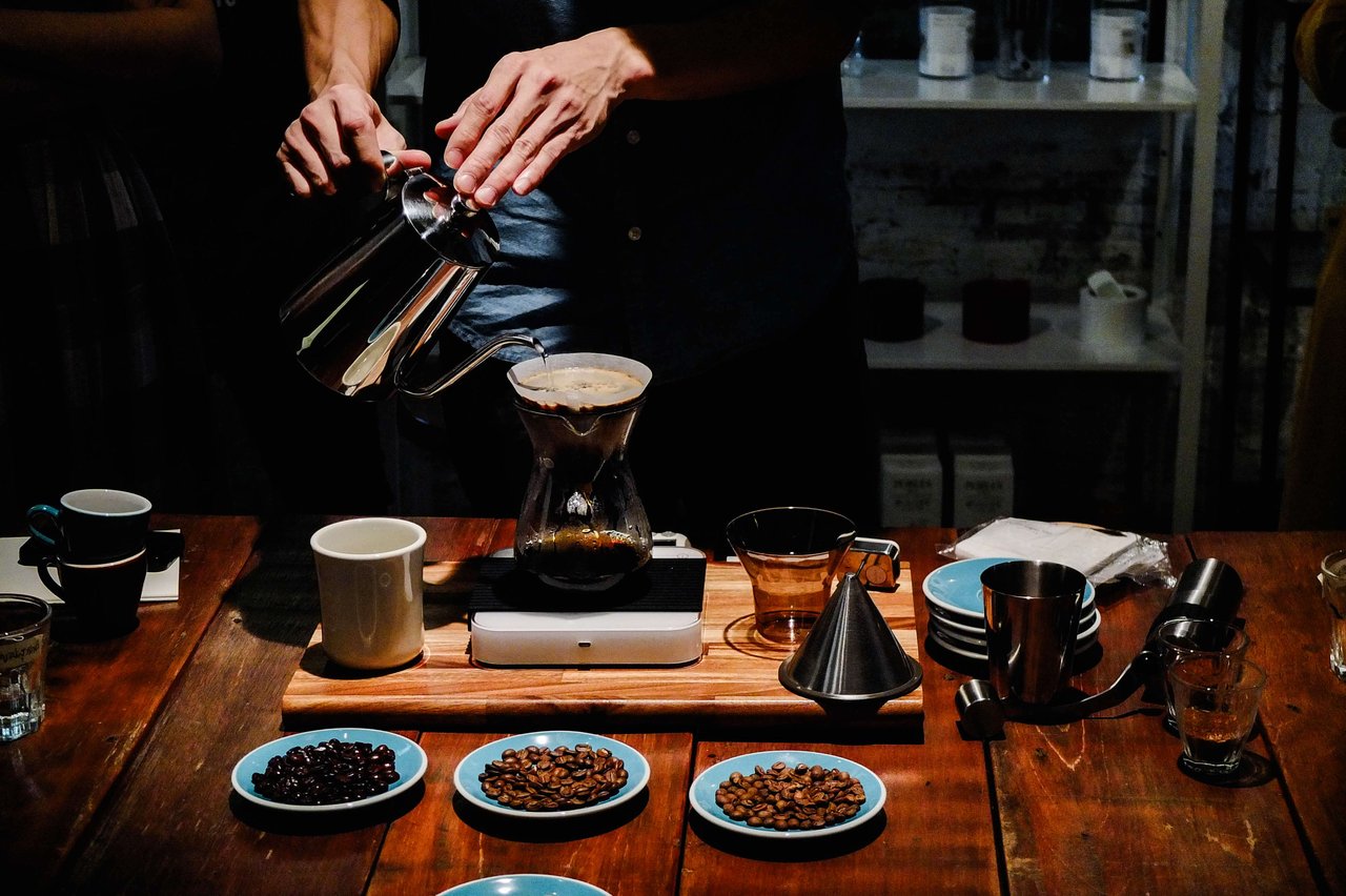 person makes pour over coffee high-end tasting