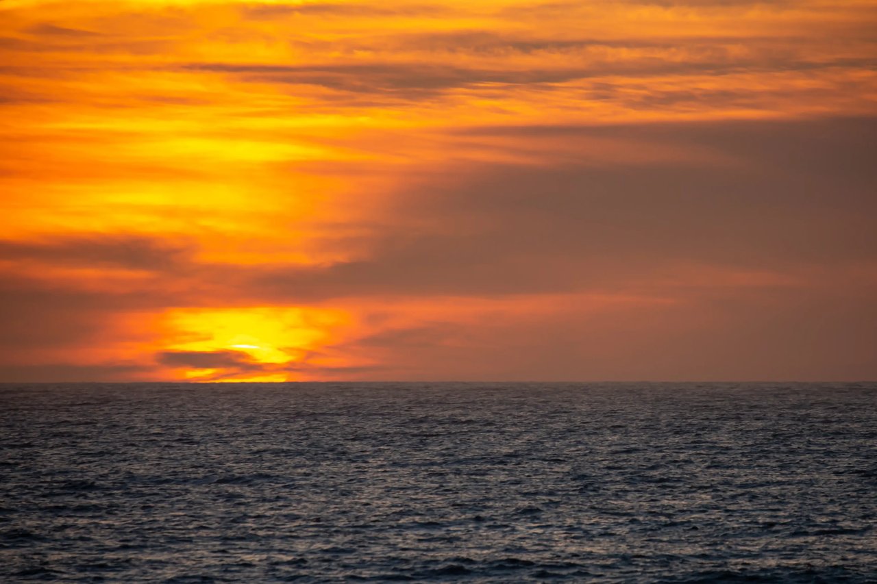 Bright orange sunset over a dark windy ocean in Gearhart Oregon