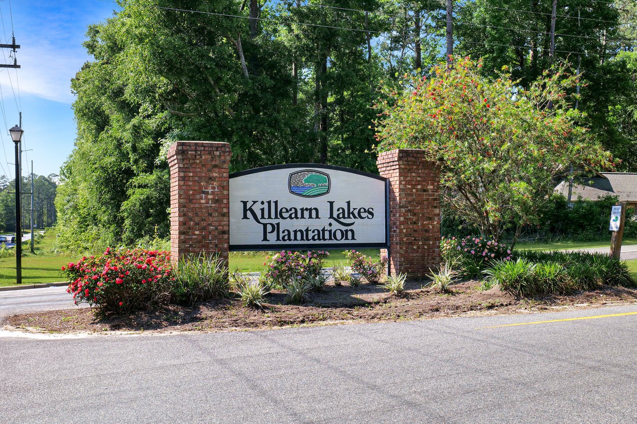 A ground-level view of the entrance sign for "Killearn Lakes Plantation," marking the entrance to the community.