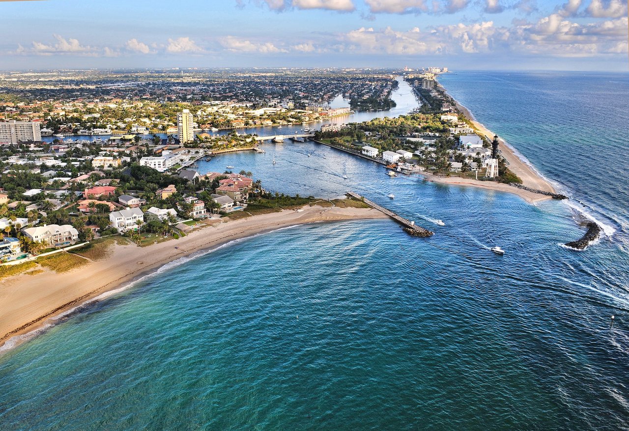 Aerial view of a city and the ocean. The city is located on the coast and has tall buildings and houses.