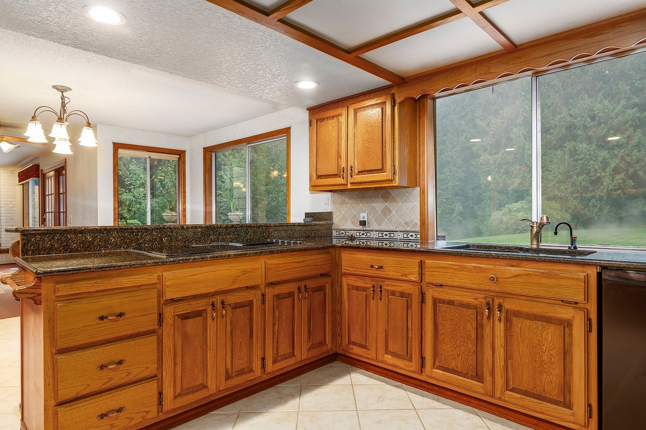 Welcome to the kitchen, where oak cabinets provide ample storage and a window over the sink offers a delightful view of your private backyard. This space seamlessly combines functionality and natural beauty.