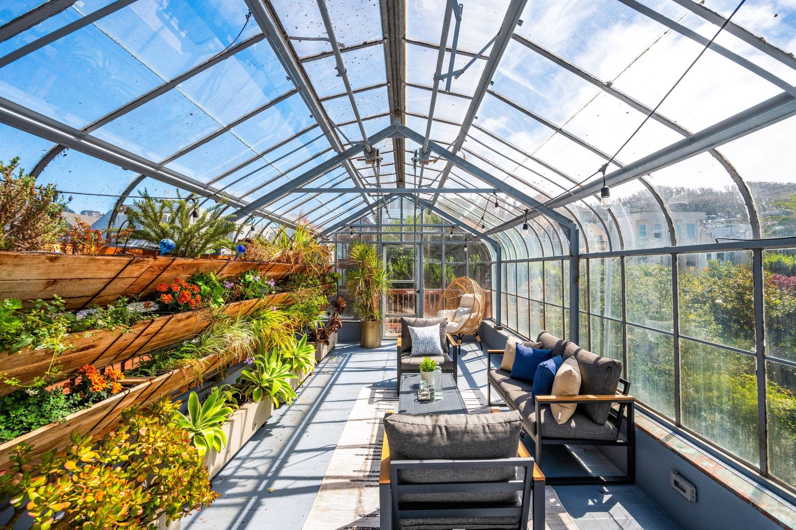 Wind-protected rooftop greenhouse with seating and planting beds at 449 Frederick Street, Cole Valley