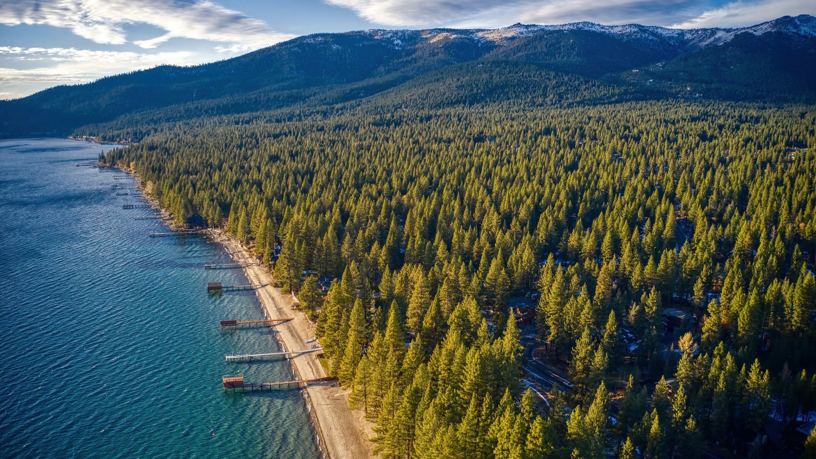 Private piers reaching into Lake Tahoe from a sandy stretch of lakefront homes in Incline Village, Nevada