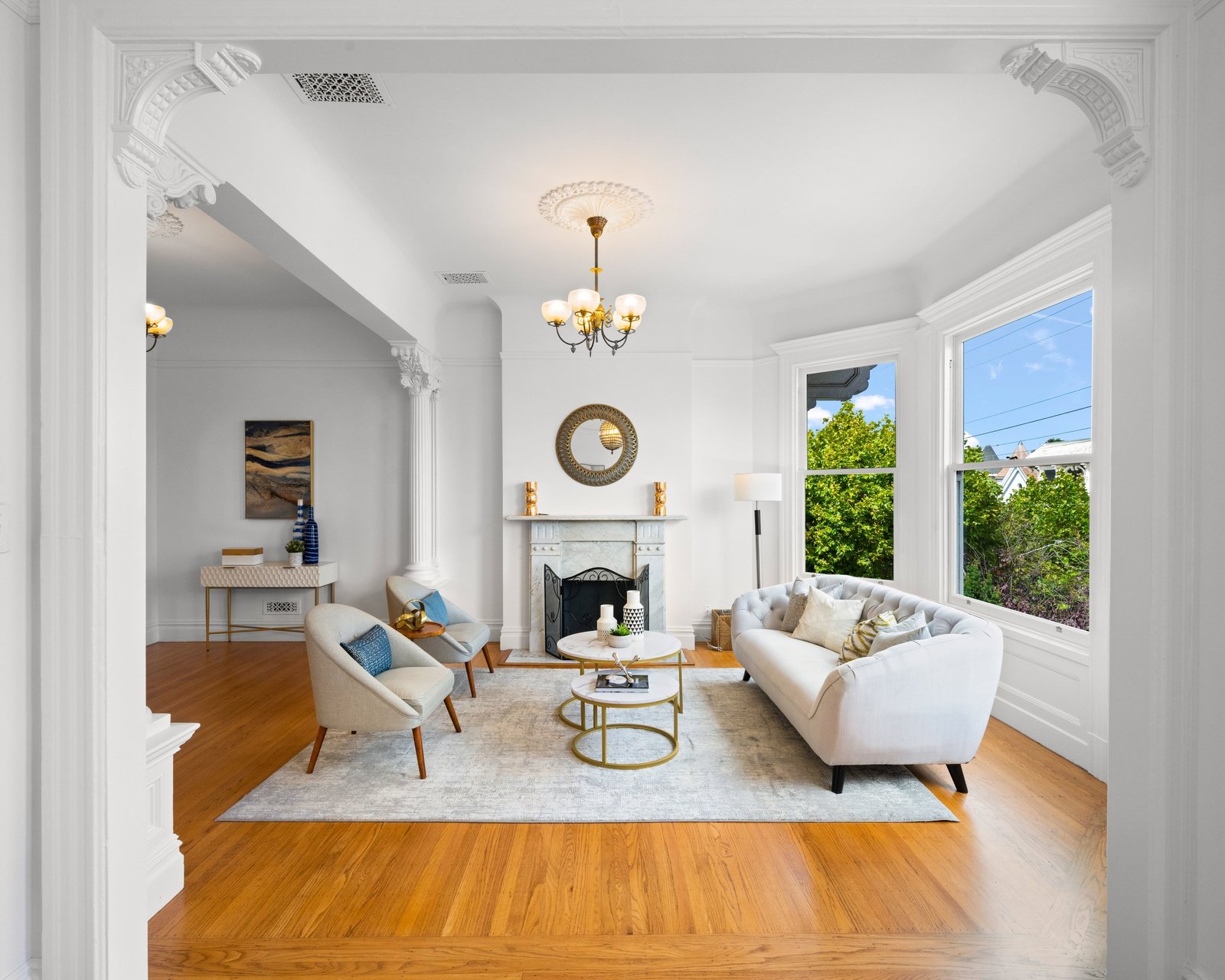 Parlor with decorative fireplace, bay window and oak floors at 449 Frederick Street, Cole Valley