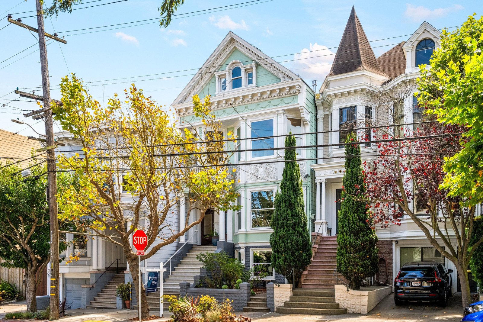 Front facade of 449 Frederick Street, a green Victorian on a tree-lined block in Cole Valley, San Francisco