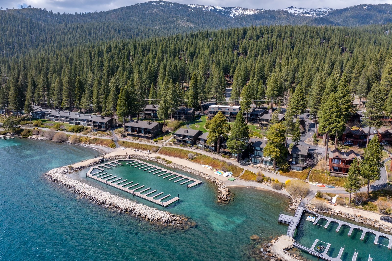 Aerial view of the Crystal Shores West and Crystal Shores East lakefront condominiums on Lakeshore Boulevard in Incline Village, each with a private boat marina, beside a sandy beach on Lake Tahoe