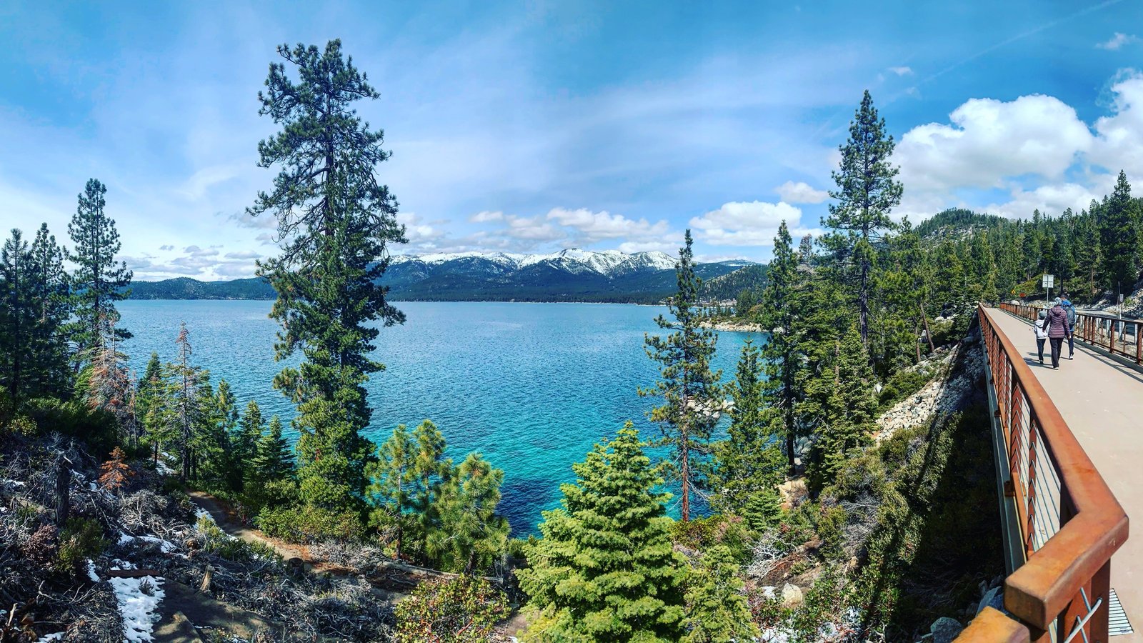 Walkers on the raised Tahoe East Shore Trail above clear blue Lake Tahoe water near Incline Village