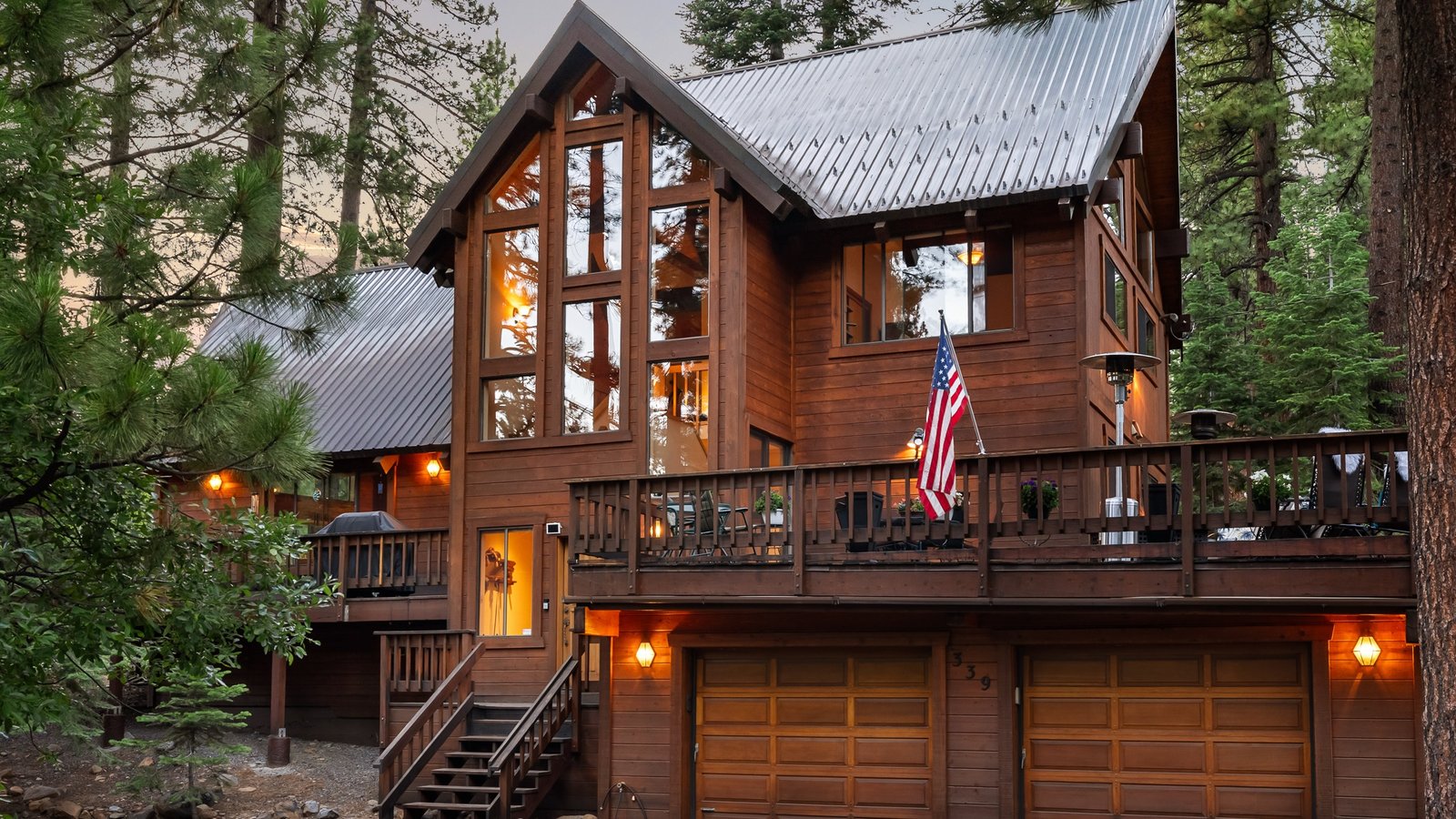 Wood-sided mountain home with tall windows, a wraparound deck and a two-car garage at 344 Country Club Drive on Incline Village’s Eastern Slope