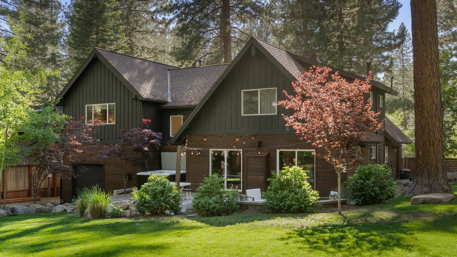 Two-story dark green home with a level lawn and gardens at 178 Tramway Road in Mill Creek, Incline Village