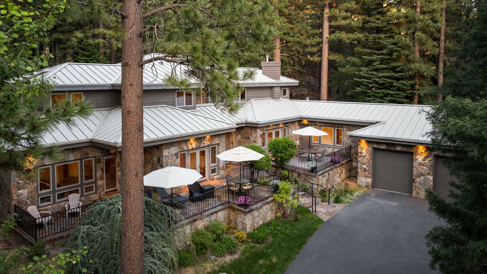 Stone and timber estate home with patios and a long driveway at 250 Estates Drive in Incline Village’s gated Estates Drive enclave