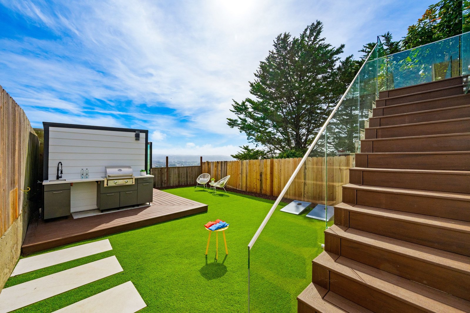 Deck stairs down to the flat yard and built-in grill station at 15 Shields Street