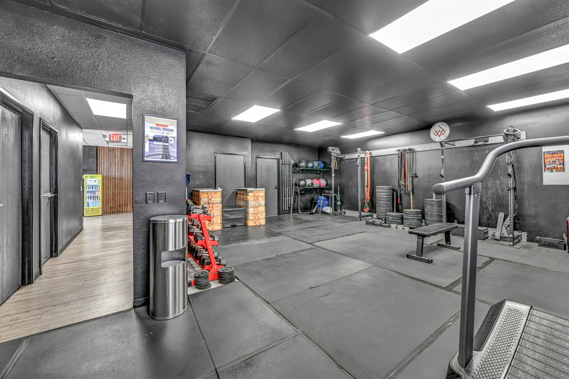 Gym with weight machines, plate racks, and rubber flooring.