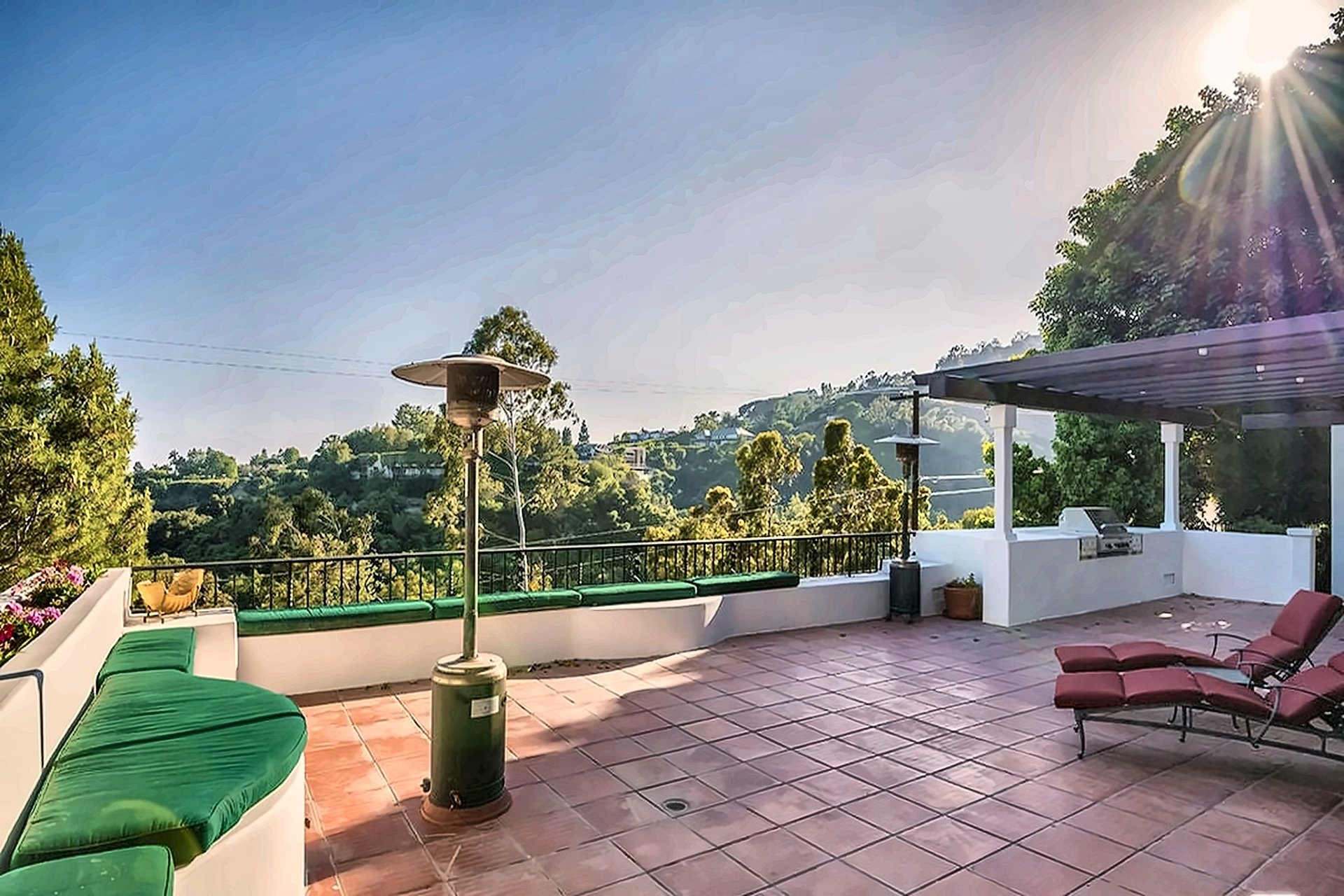 Tiled view terrace with lounge seating overlooking a green Brentwood canyon