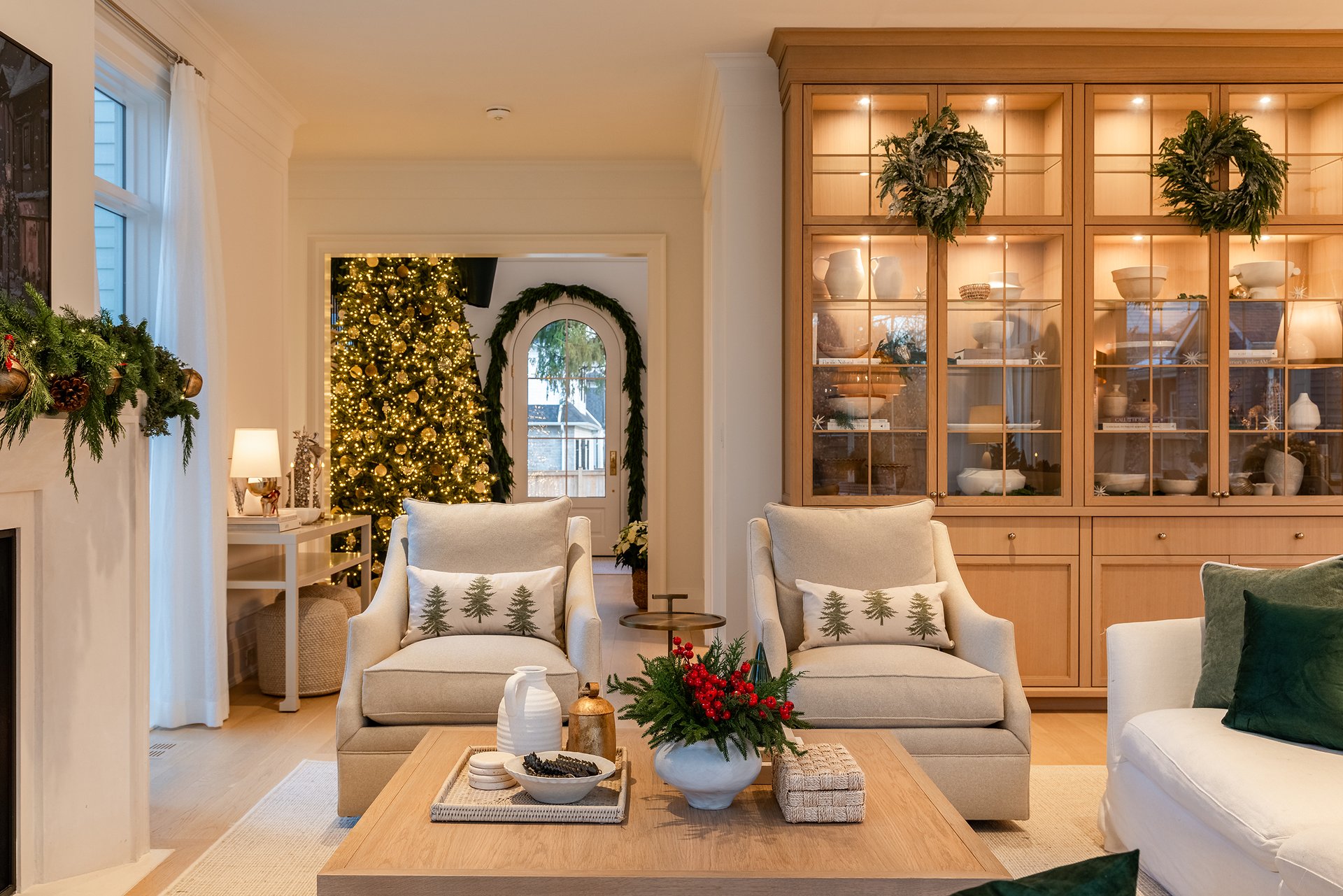 Open-concept living room and kitchen in an Oakville custom home featuring soft neutrals, green velvet accents, and Christmas d&eacute;cor.