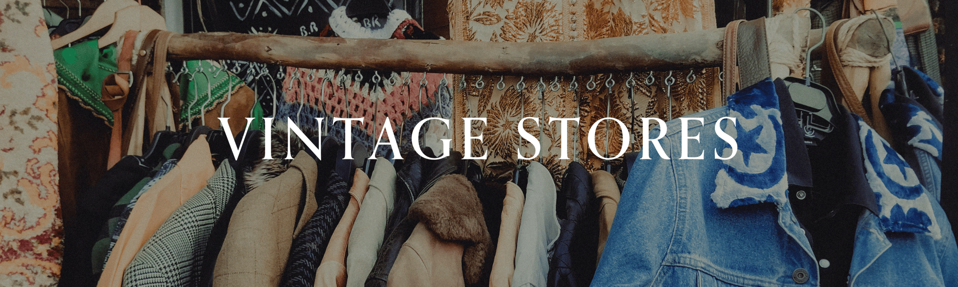 A display of various vintage clothing items hanging on a rack, with the text "VINTAGE STORES" prominently featured.