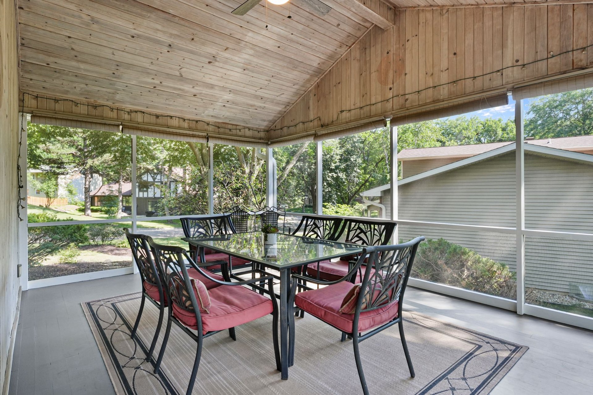 Vaulted screen porch with wood ceiling and dining seating at 10 Stonecrest Circle in Madison.