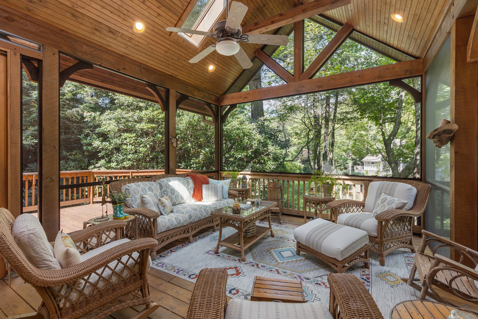 Screened porch with wicker seating at 21 Crescent Trail in Cullasaja Club, Highlands NC