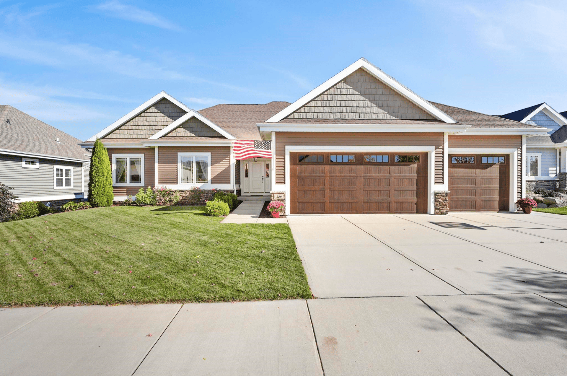 A stunning modern ranch-style home in Waunakee, Wisconsin, featuring a three-car garage and stone exterior, representing the high-quality real estate available in the $550,000 to $800,000 price range.