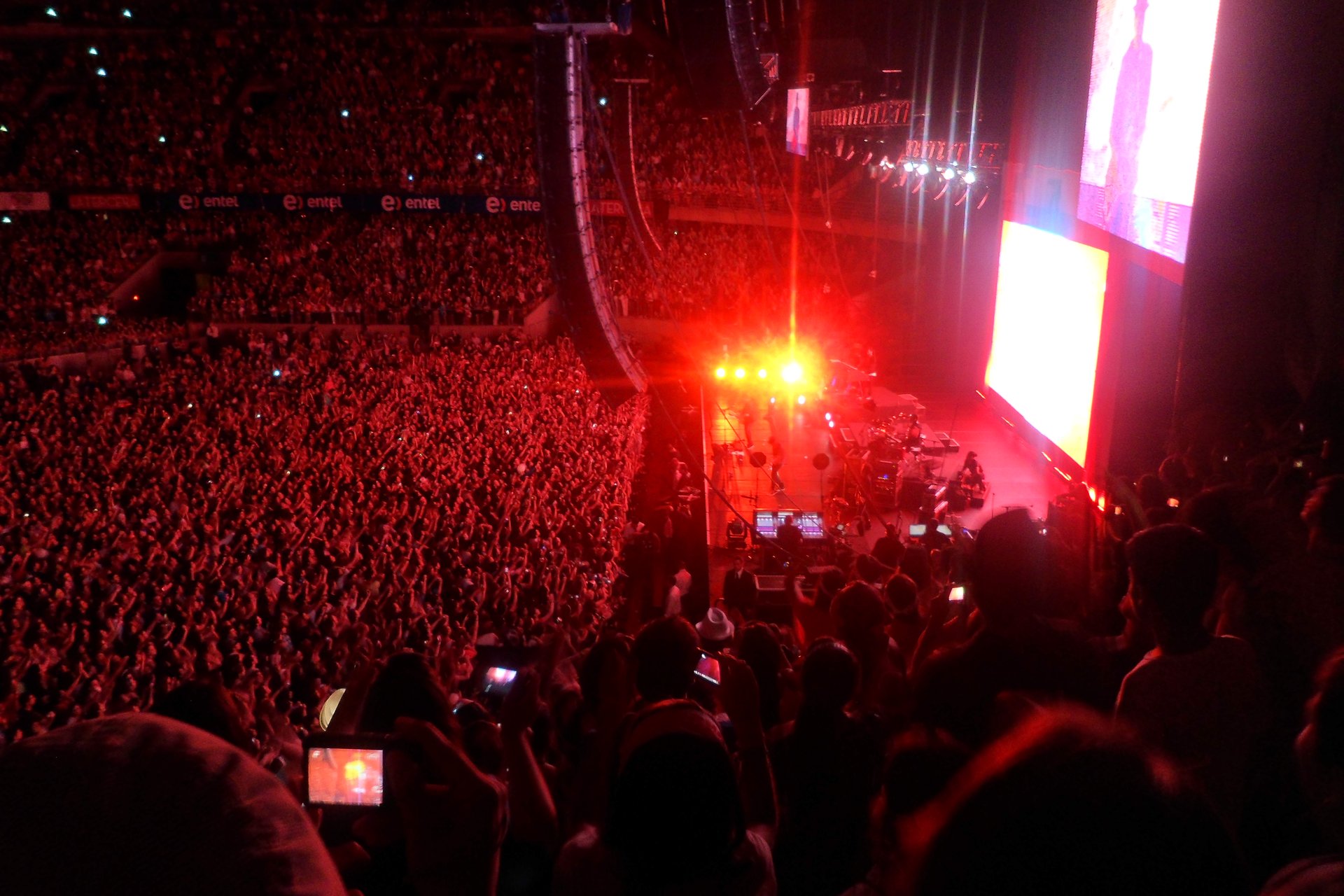 Large stadium crowd watching a live concert performance
