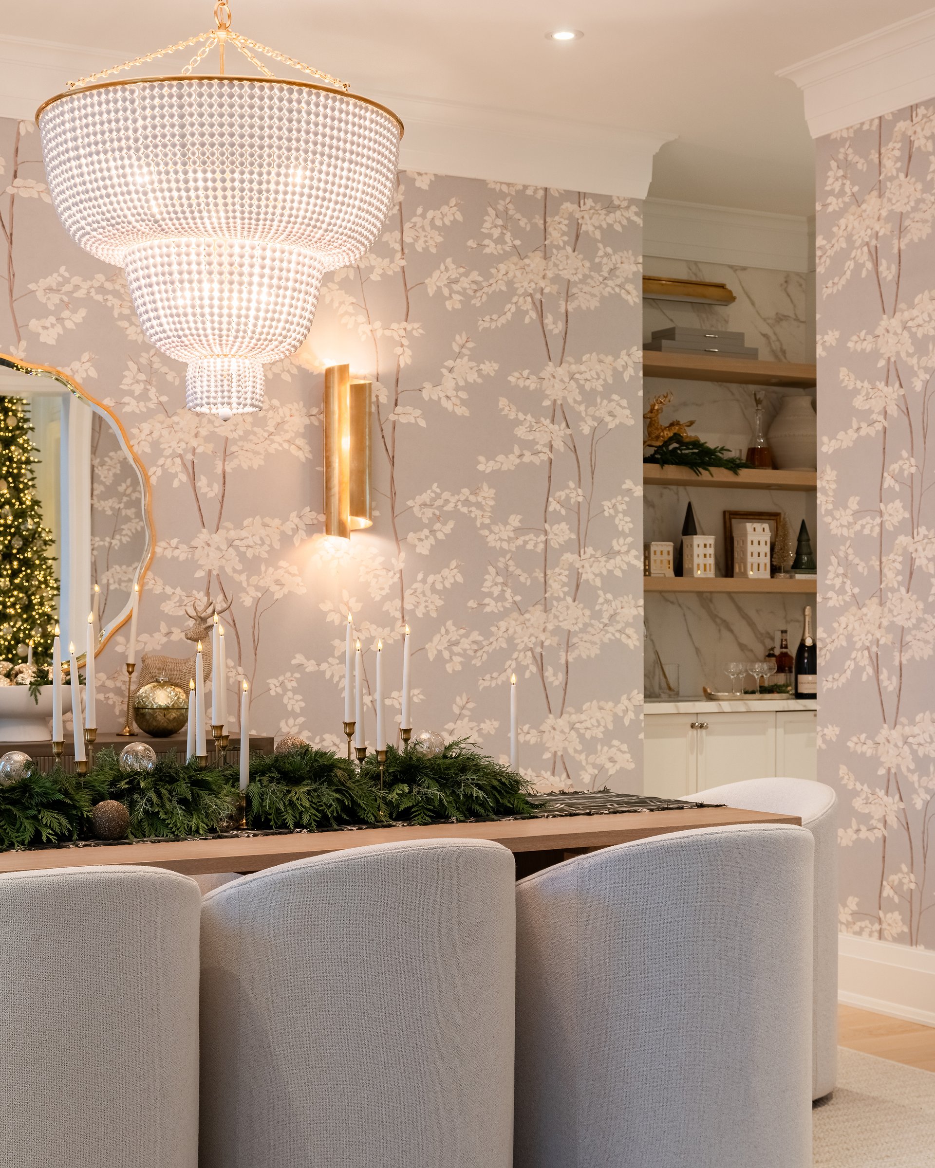 Dining room in an Oakville custom home with beaded chandelier, Lewis and Wood wallpaper, and holiday greenery centerpiece.