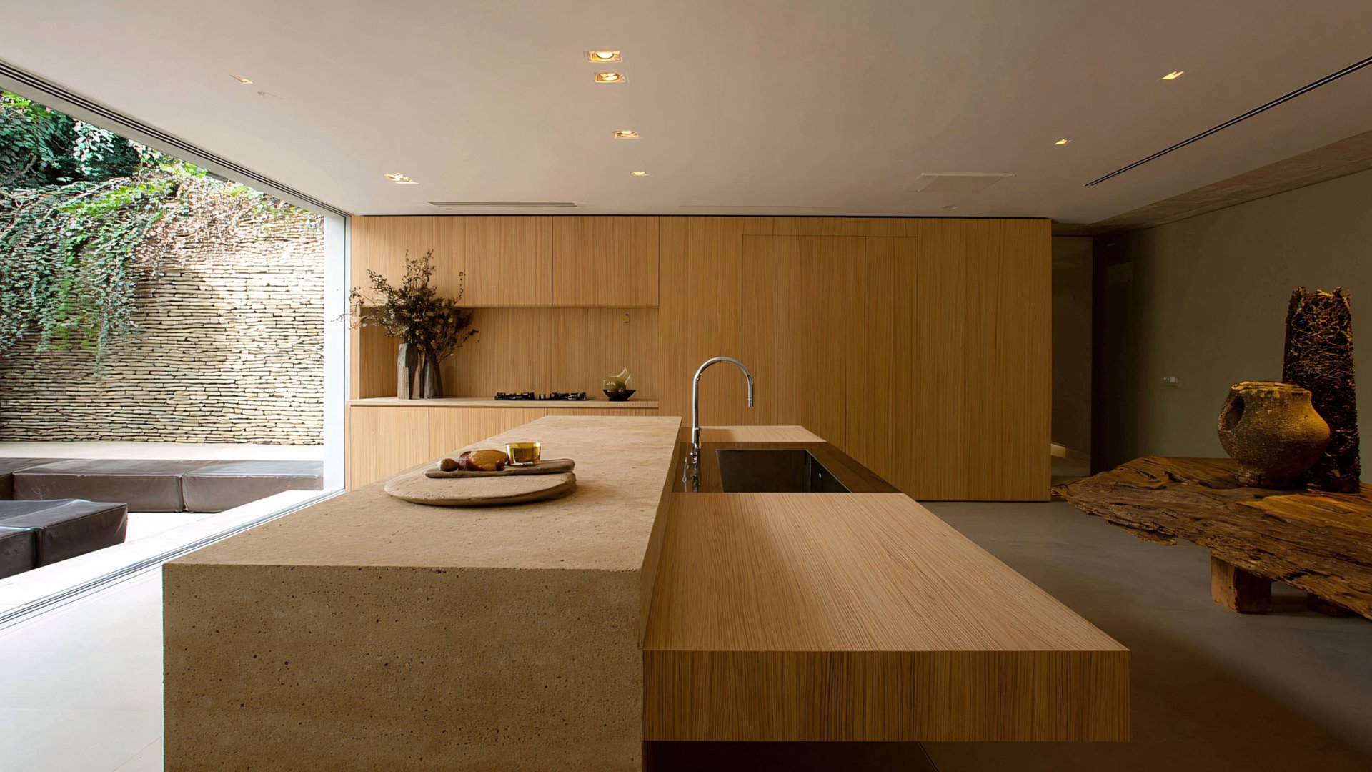 Minimalist wood kitchen with stone island and seamless indoor-outdoor connection - The Edit Real Estate Miami