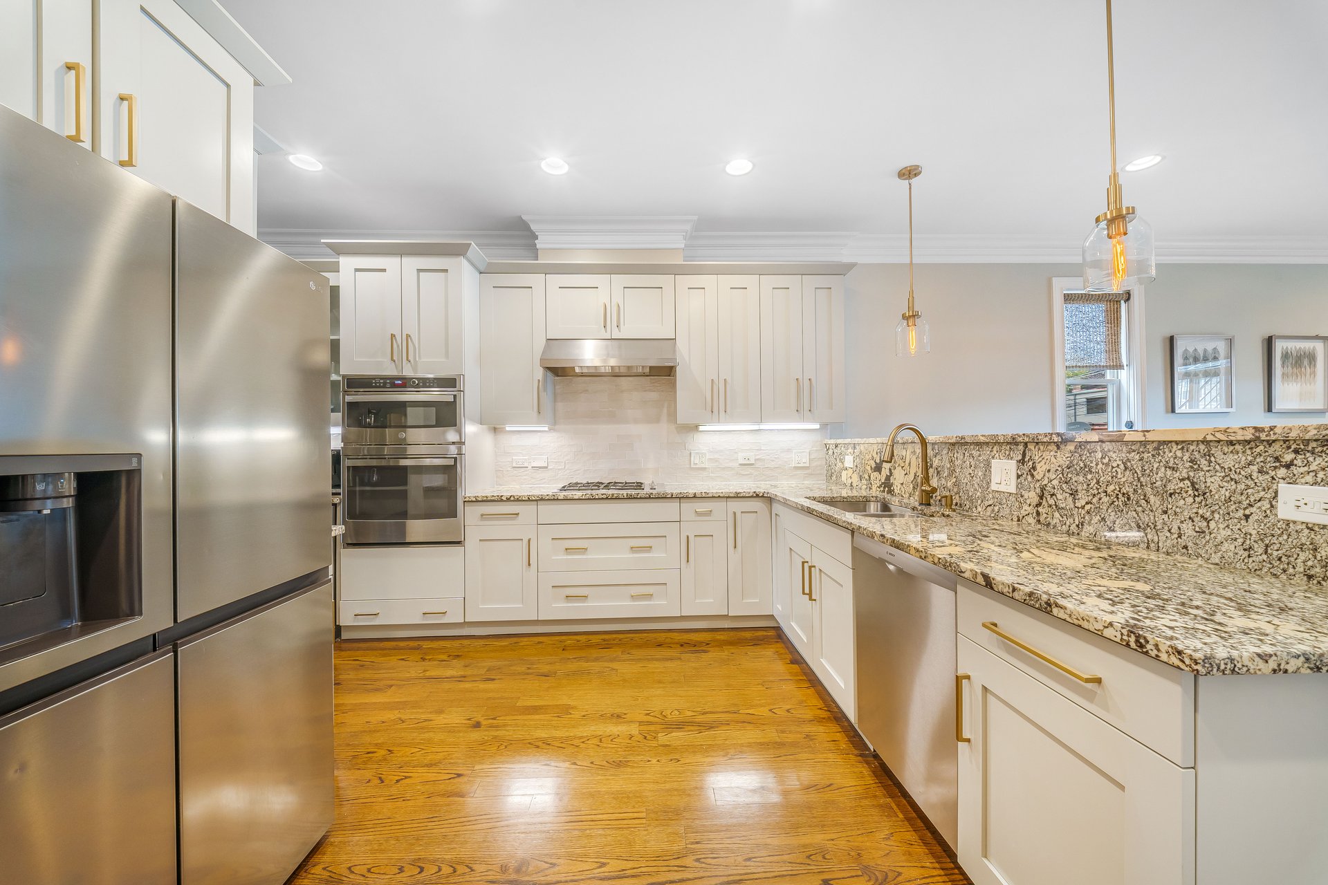 Kitchen with white cabinets, granite counters and stainless steel appliances in a duplex condo near Horner Park, Chicago