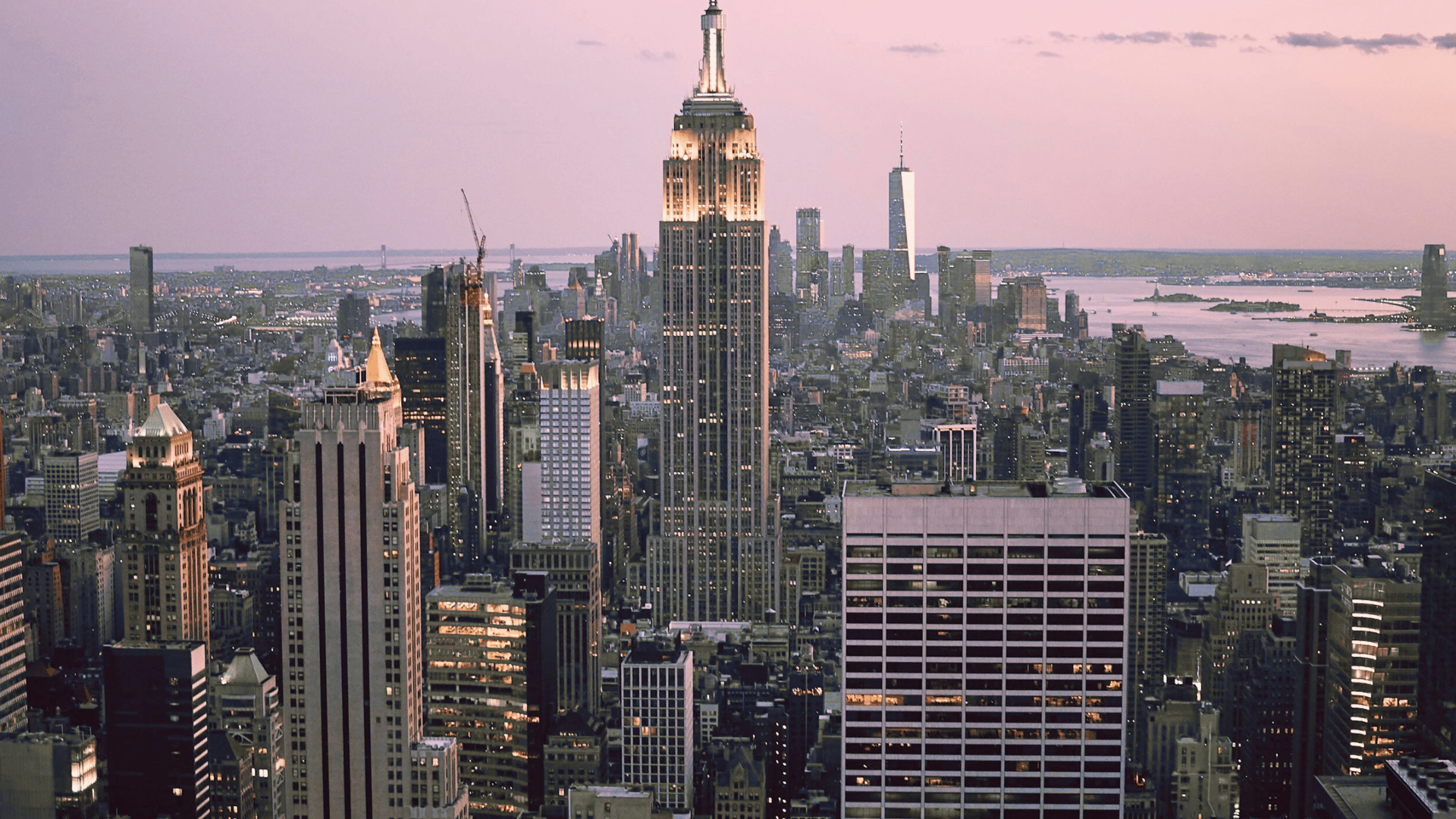 Manhattan skyline aerial view with Empire State Building and dense high-rise development at sunset
