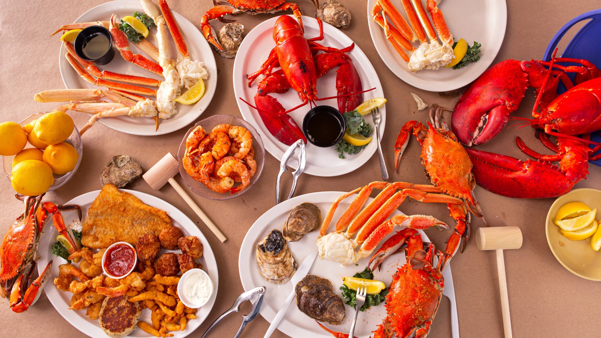 Fresh seafood feast with lobsters, crab legs, shrimp, oysters, and fried seafood platters with lemon at South Beach Seafood Festival Miami