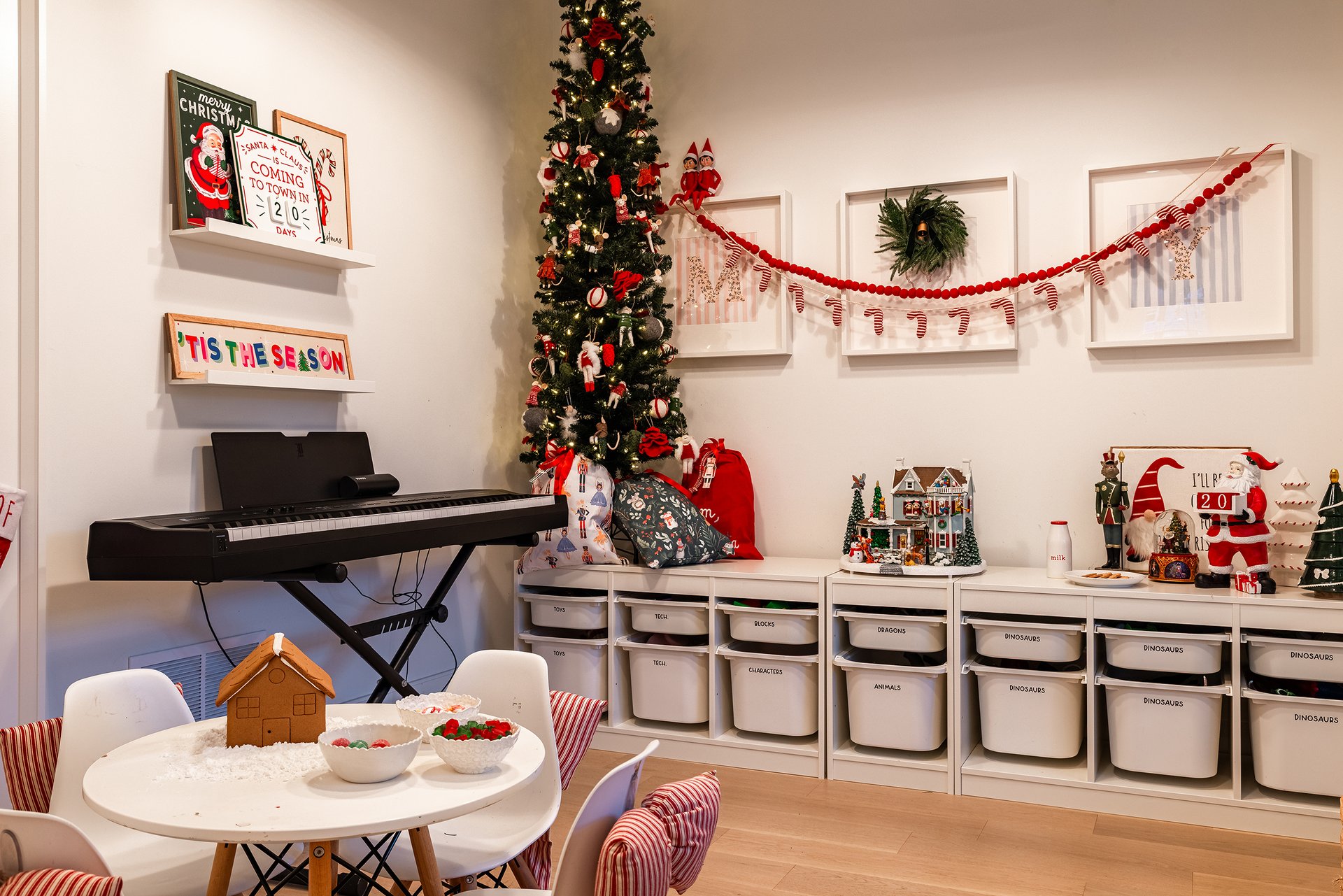 Children&rsquo;s playroom in an Oakville custom home featuring a holiday tree, craft table, and organized storage wall.