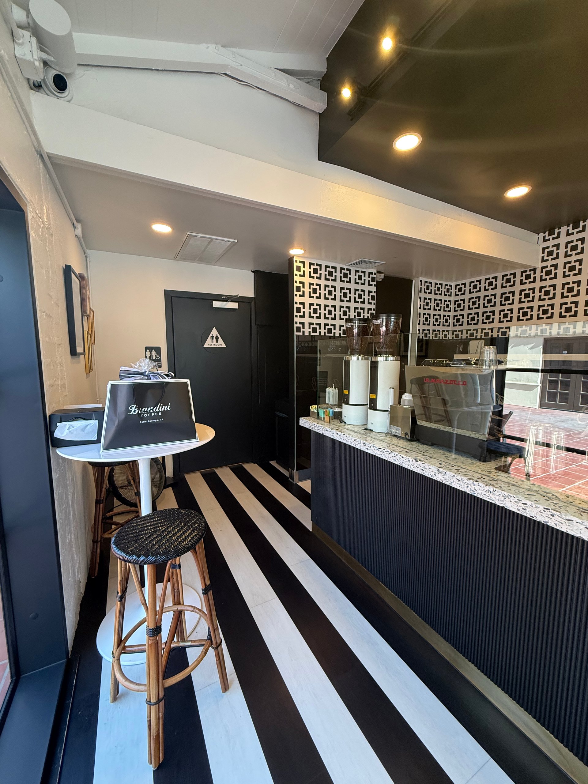 Black-and-white striped floor and dessert counter inside Brandini Toffee in Palm Springs