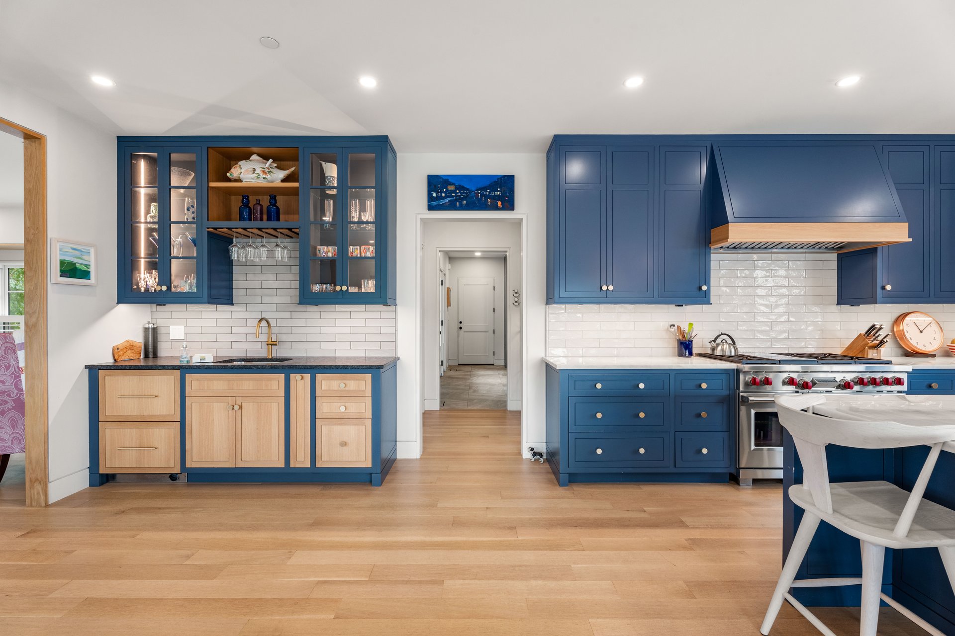 Kitchen with deep blue cabinetry, light wood fronts, and a stainless steel range.