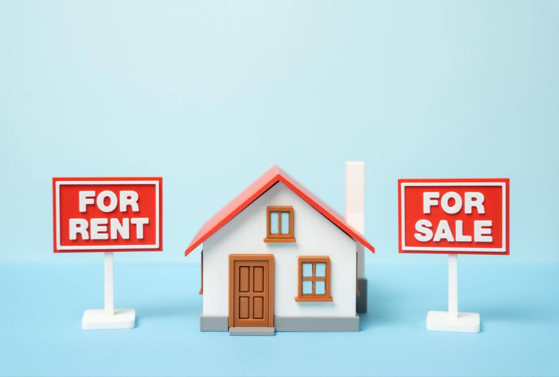 small-model-house-with-a-red-roof-is-flanked-by-signs-reading-for-rent-and-for-sale-against-a-light-blue-background