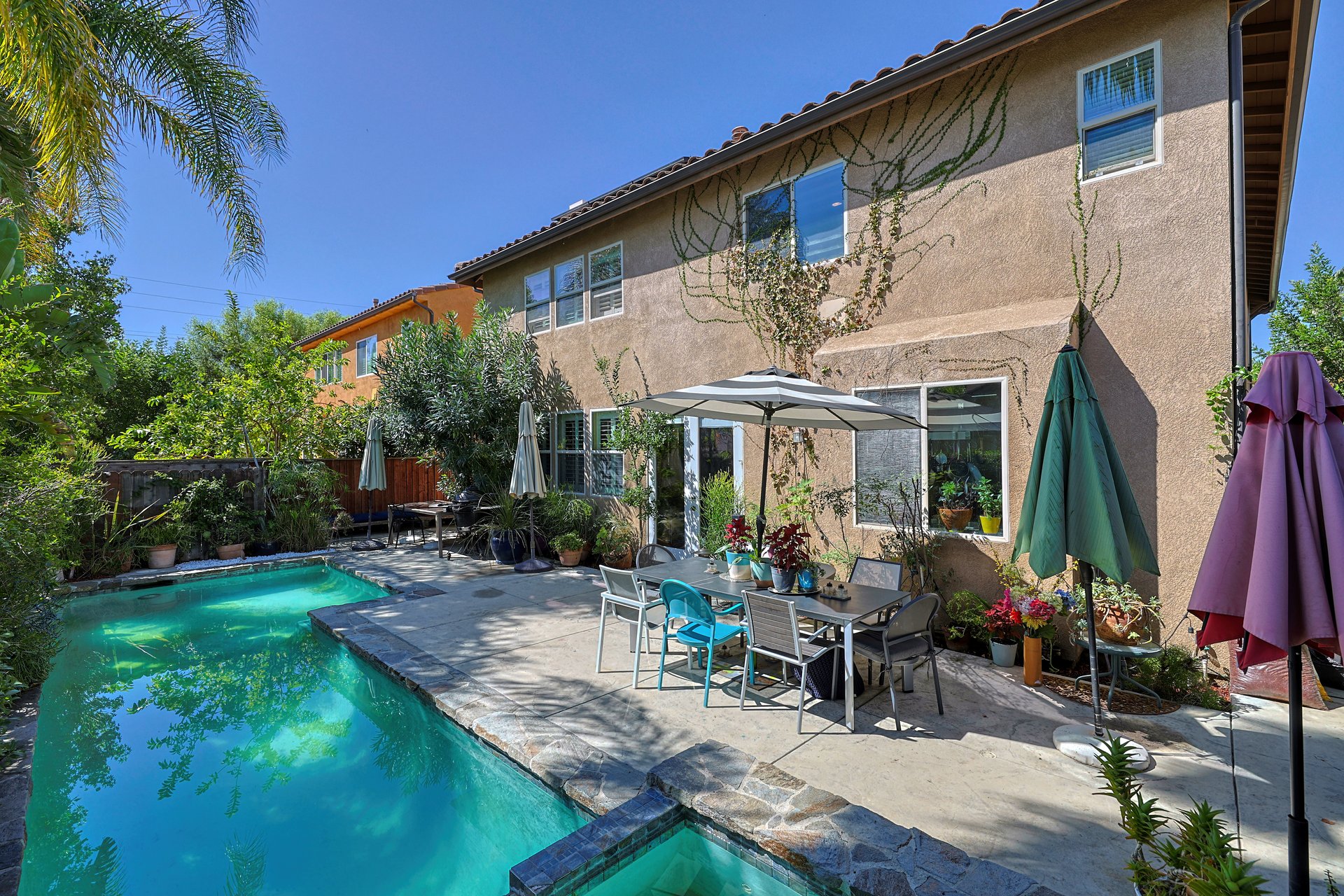 Private backyard pool with patio seating and mature landscaping