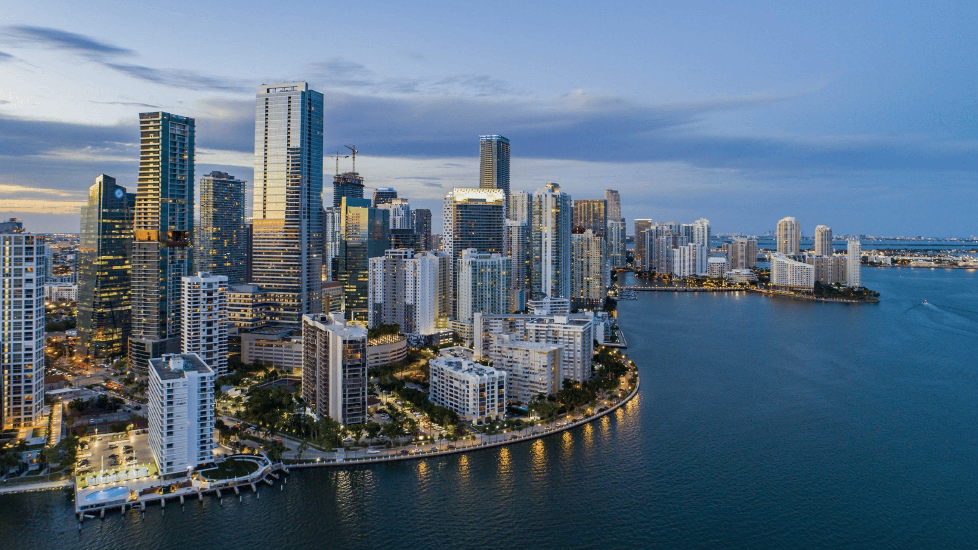 Aerial view of NYC waterfront district with luxury high-rise condominiums along the water at sunset