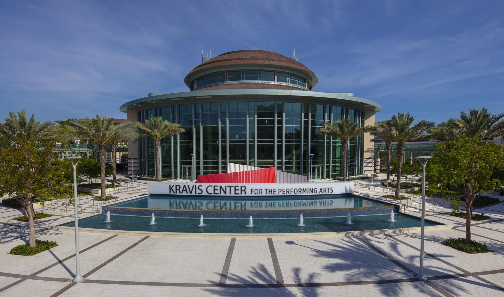 Kravis Center for the Performing Arts, with palm trees and fountains in front.