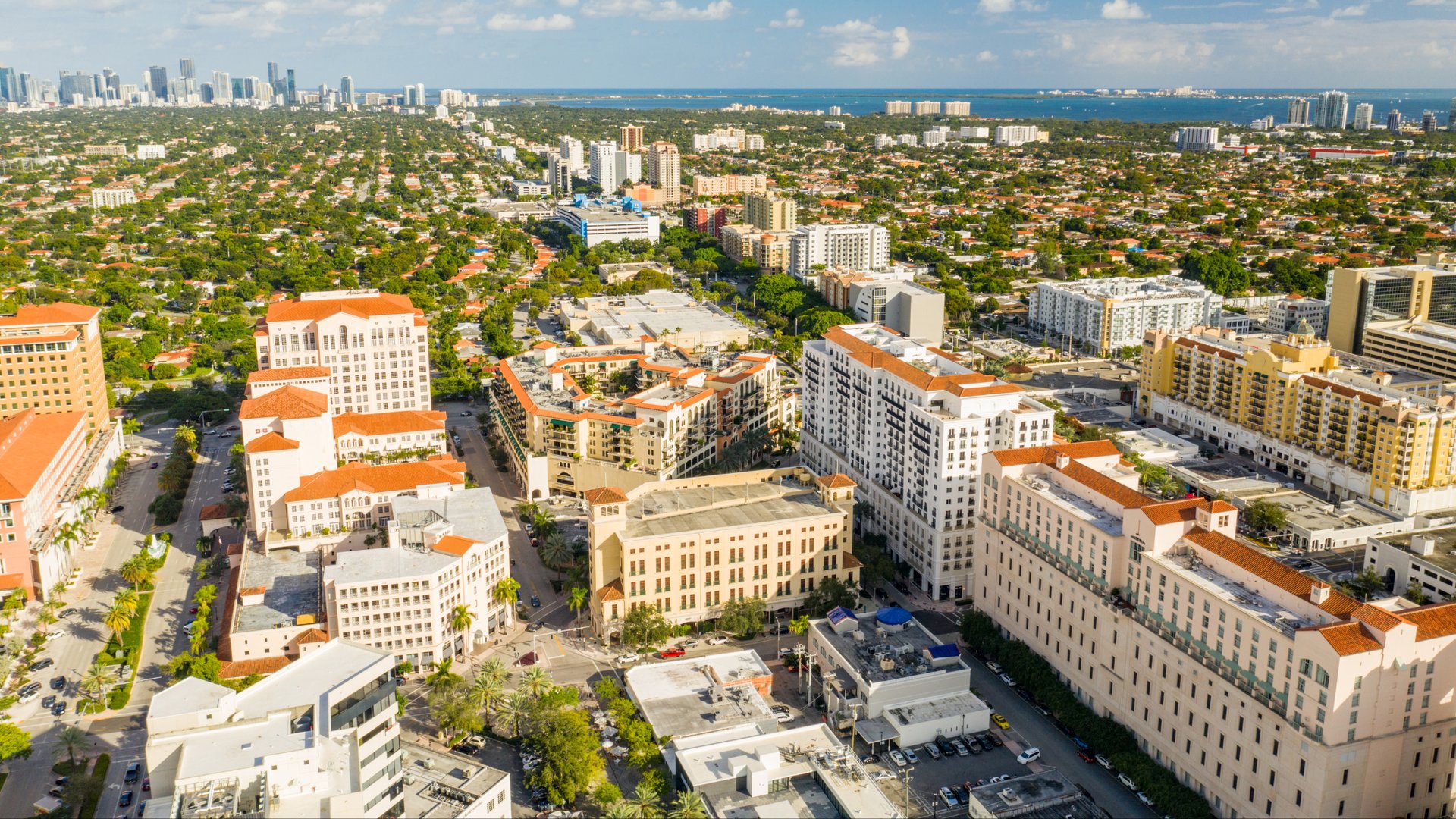 Aerial view of Coral Gables Miami showing Mediterranean buildings with orange tile roofs - The Edit Real Estate
